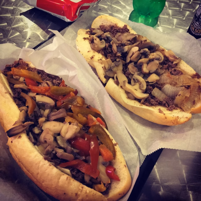 Philly cheesesteak recipe using grocery store shaved beef: sauté onions, brown the beef in 3 minutes, melt provolone and Whiz on a toasted hoagie roll.