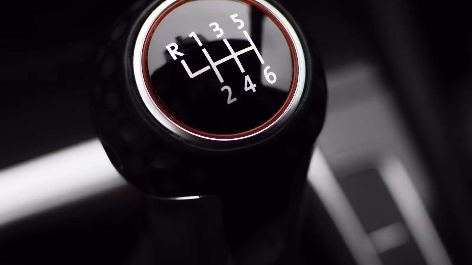 Close-up of a six-speed manual transmission gear shift knob showing the shift pattern